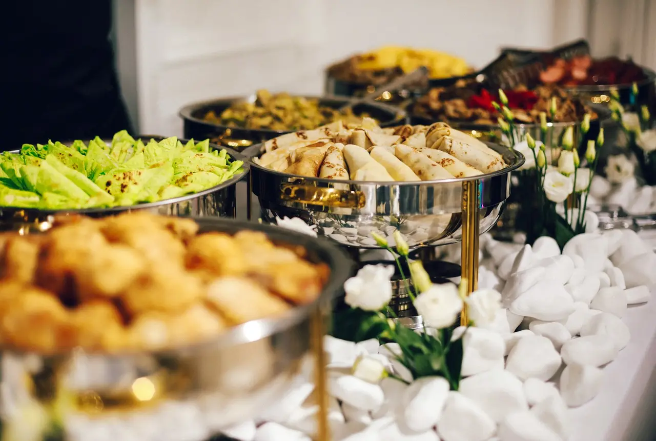Mesa de buffet con bandejas de comida en un evento