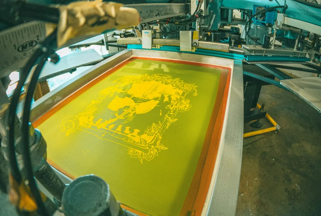Máquina de serigrafía imprimiendo un diseño amarillo