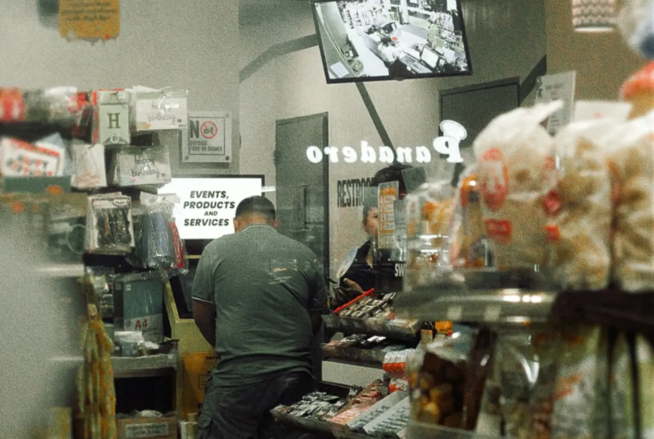 Cliente comprando en un minimarket lleno de productos